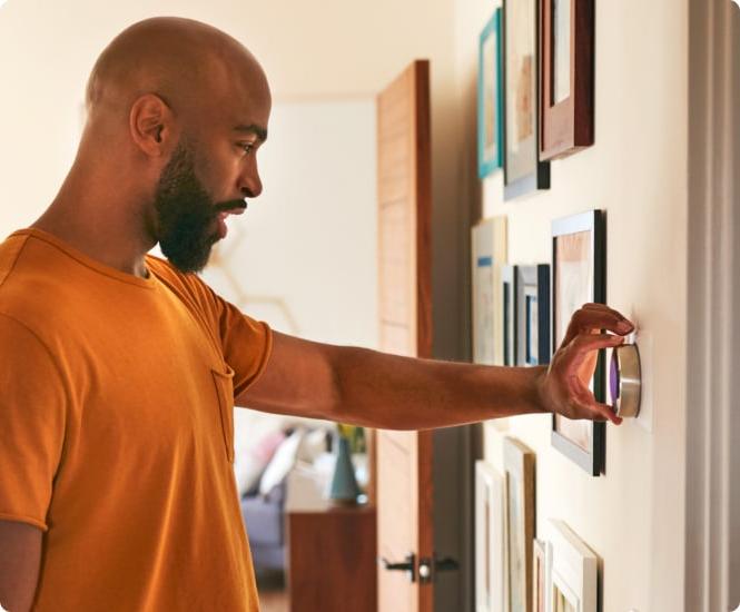 Man adjusting thermostat